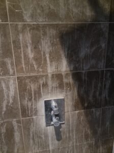 A Nero Marquina Shower wall that has been damaged by an acid cleaning product-min
